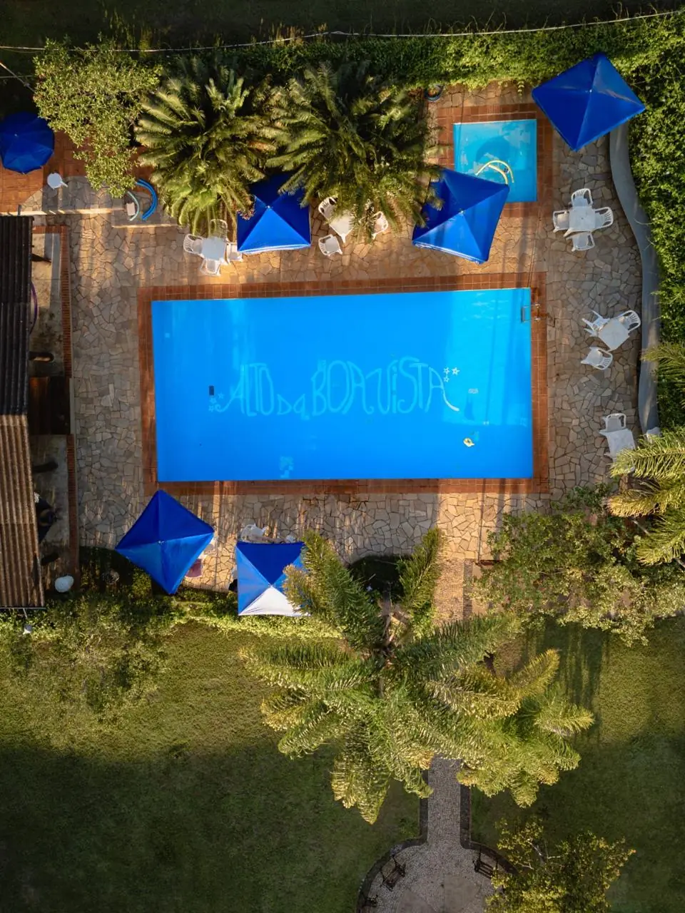 Vista aérea da piscina com guarda-sóis azuis