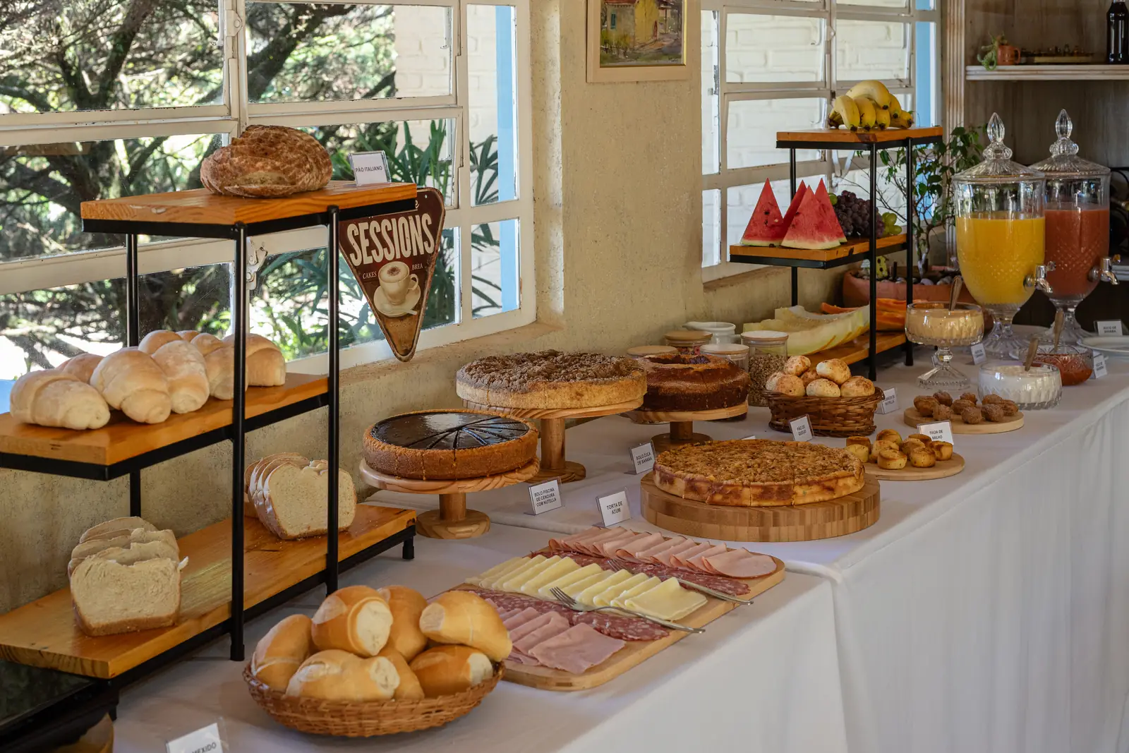 Pães, frios e tortas nas estantes de madeira do café colonial
